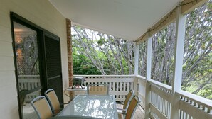 A covered patio with a table and chairs, a grill, and a view of trees. - Spacious, comfortable, Pet Friendly 3-Bed House minutes from the Big Pineapple  (Woombye)