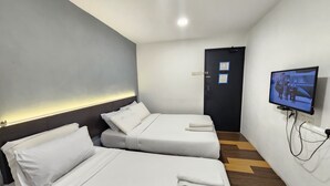 Een hotelkamer met twee bedden, een aan de muur bevestigde televisie en een deur met een beveiligingscamera.