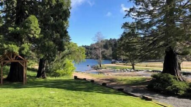 A serene lakeside park with a wooden gazebo, a clear view of the lake, and a well-maintained grassy area. - 1st Floor - 1 mile from San Moritz Lodge (Crestline)