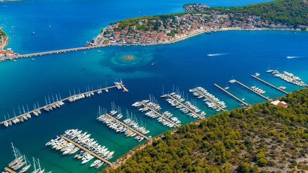 An aerial view of a coastal town with a marina filled with boats, surrounded by hills and a clear blue sea. - Apartment Miline by Interhome (Rogoznica)