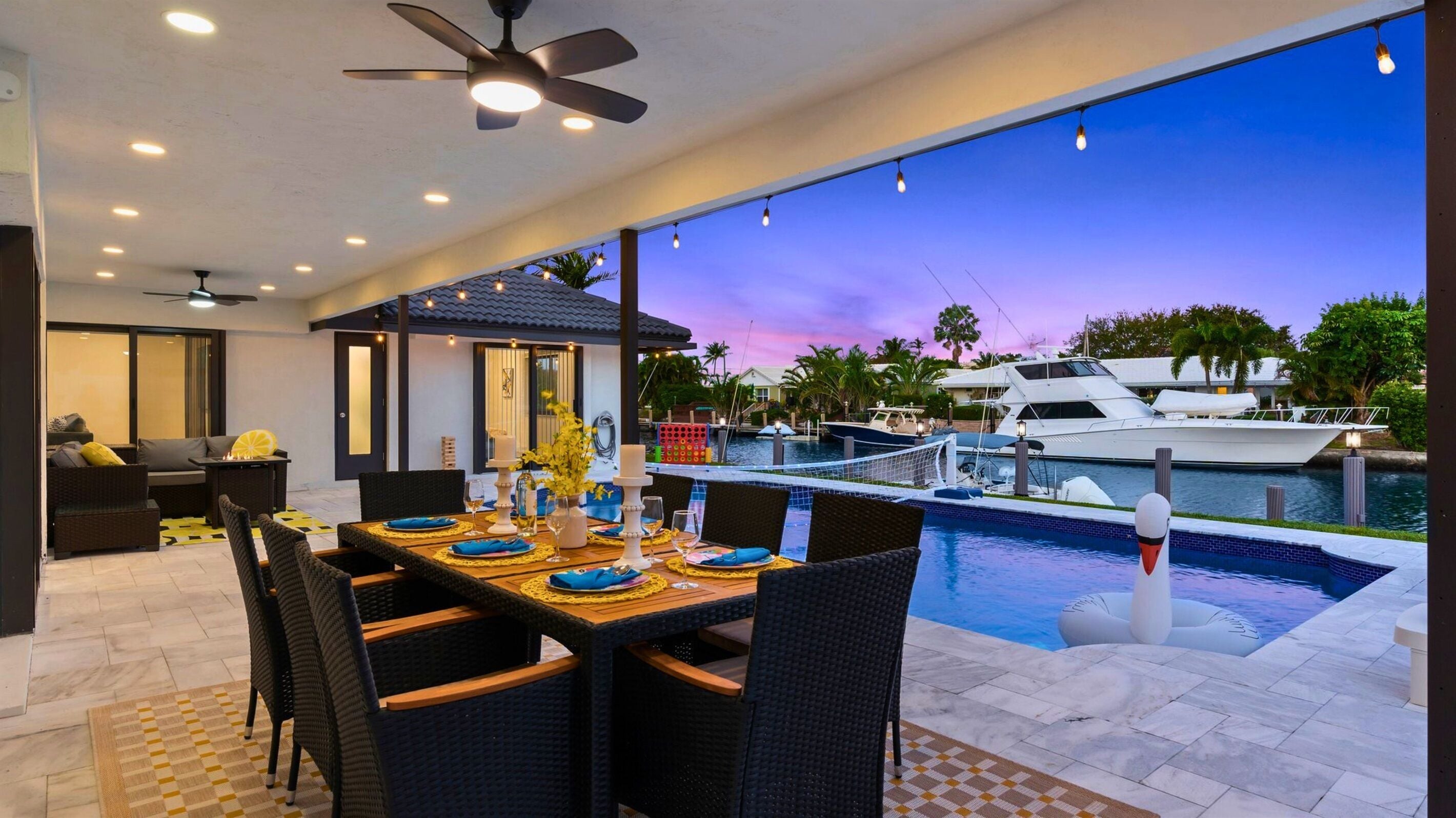 An outdoor dining area with a view of a marina and yachts.