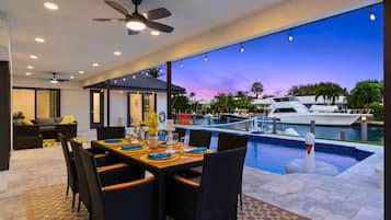 An outdoor dining area with a view of a marina and yachts.