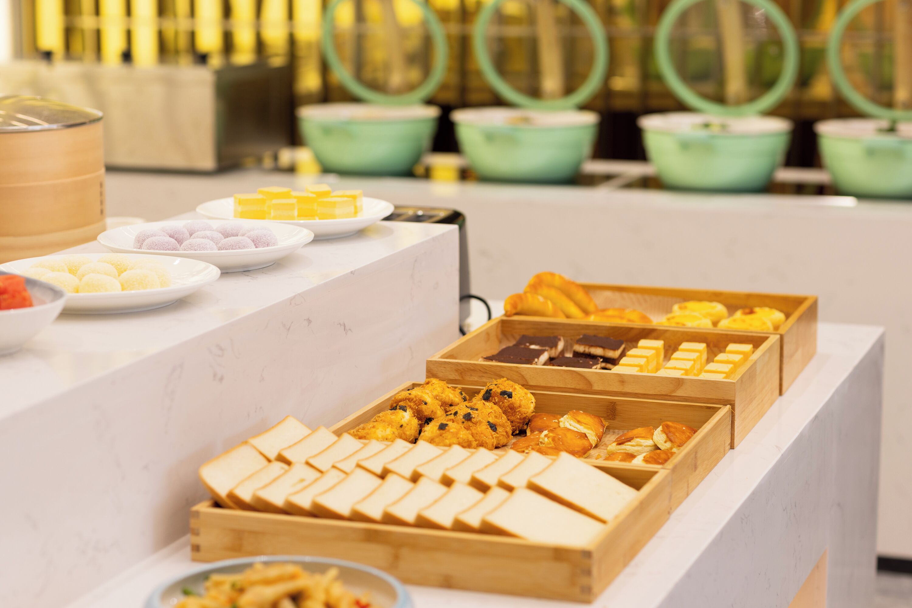 A buffet with various food items including pastries, cakes, and desserts.