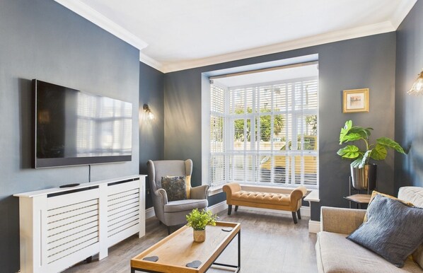 Relax in this stylish living room with a large window, flat-screen TV, and comfortable seating area.