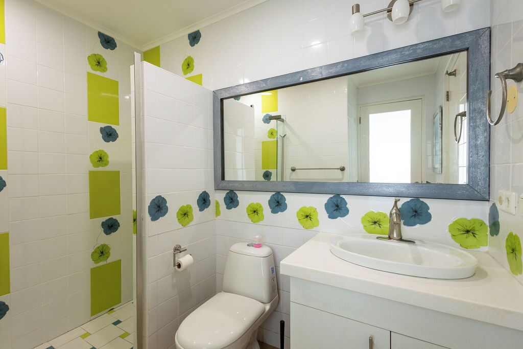 Un baño con inodoro, lavamanos y espejo.