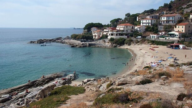 A coastal town with buildings, a beach, and rocky terrain. - La Conchiglia Apartment (Seccheto)