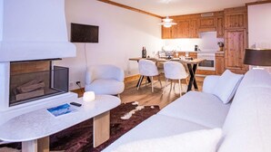 Una sala de estar moderna con chimenea, una zona de comedor y armarios de madera.