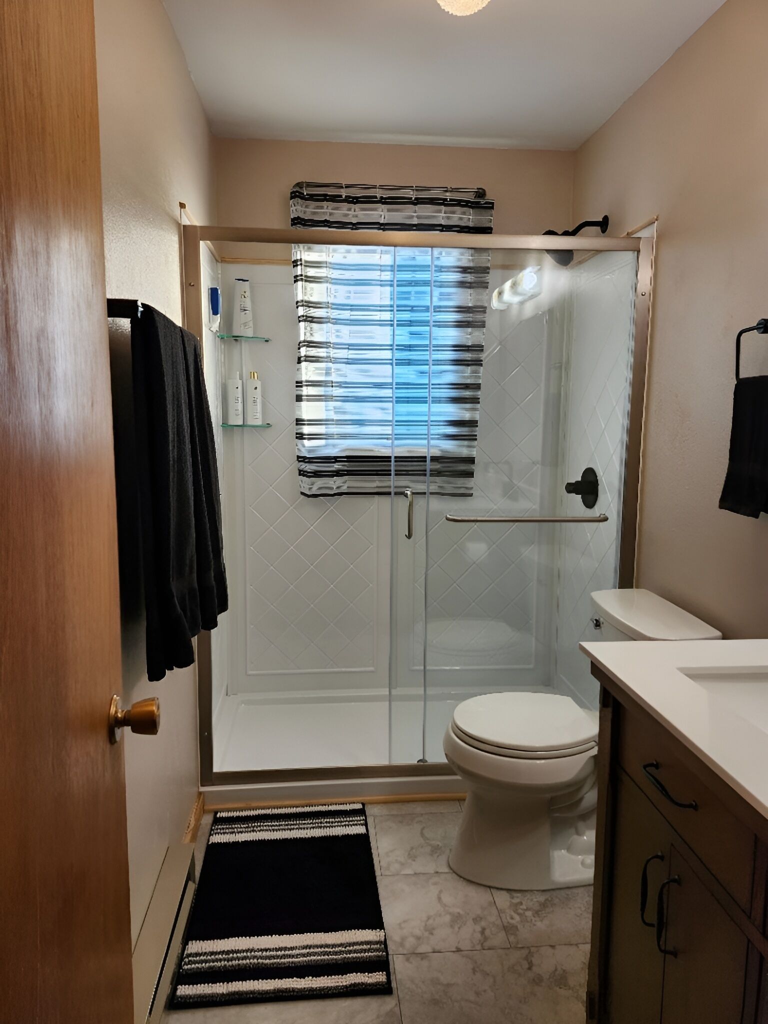 Ein Badezimmer mit Duschkabine, Toilette und Waschbecken.