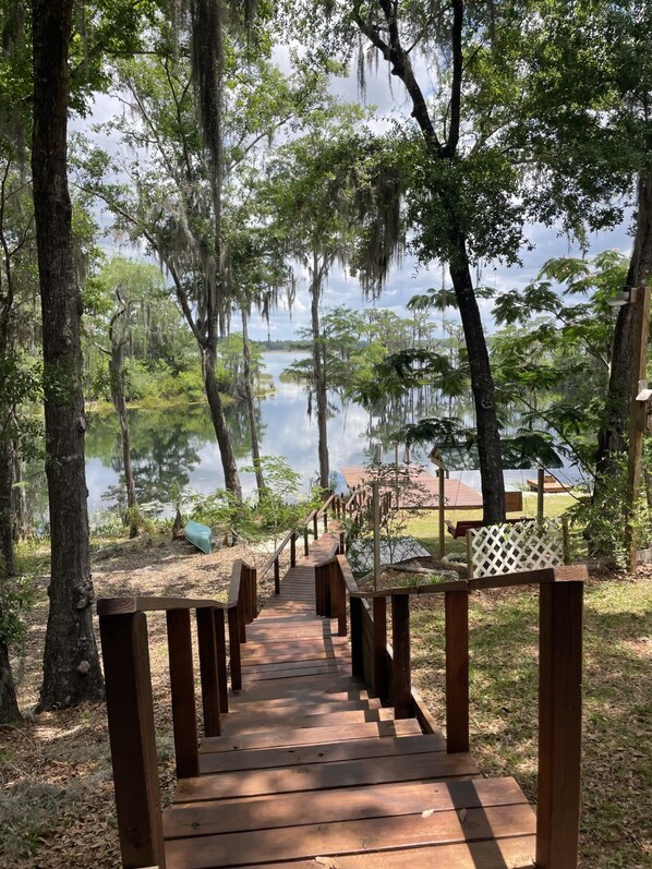 A wooden boardwalk leading to a lake with trees and a gazebo. - 4-bedroom Lake House 45 Minutes from the Beach! (Chipley)