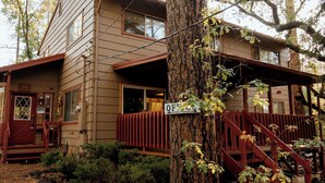 A two-story building with a red front door, a sign reading "Office," and a wooden staircase leading to a porch. - Northwoods #1 Cabin in the Pines (Pinetop-Lakeside)