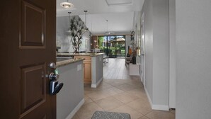 A modern kitchen with a central island, pendant lighting, and a view to the outdoor area. - Your Palm Desert Vacation Getaway at the Palm Valley Country Club is calling! (Palm Desert)