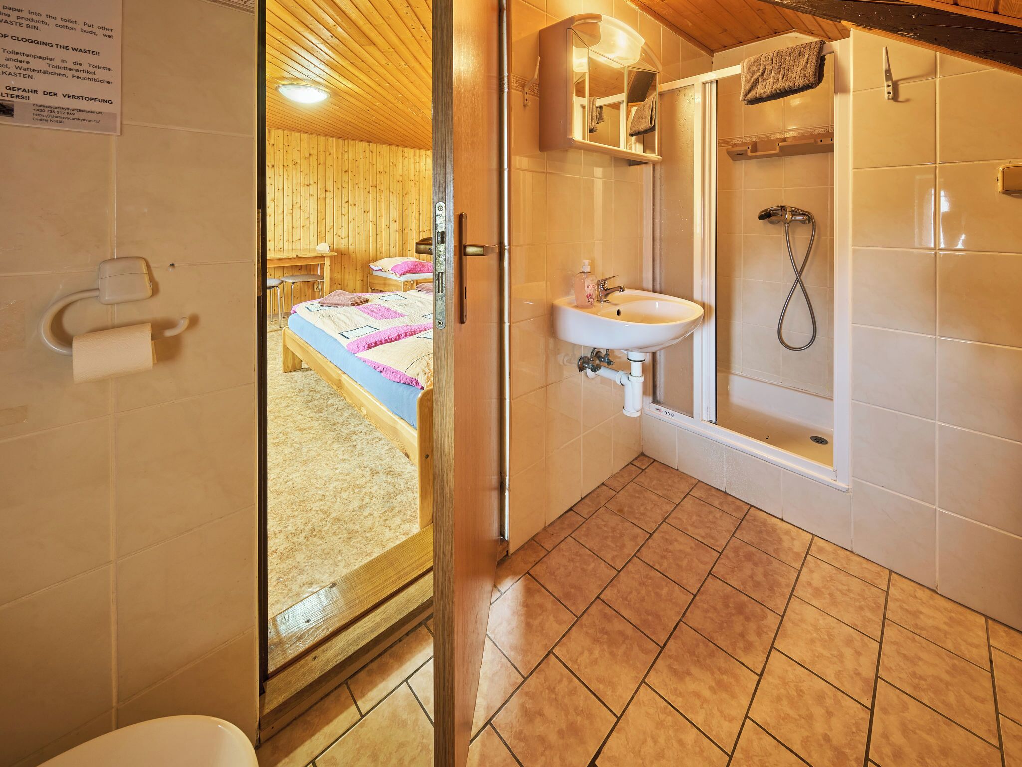 Et badeværelse med bruser, håndvask og toilet.