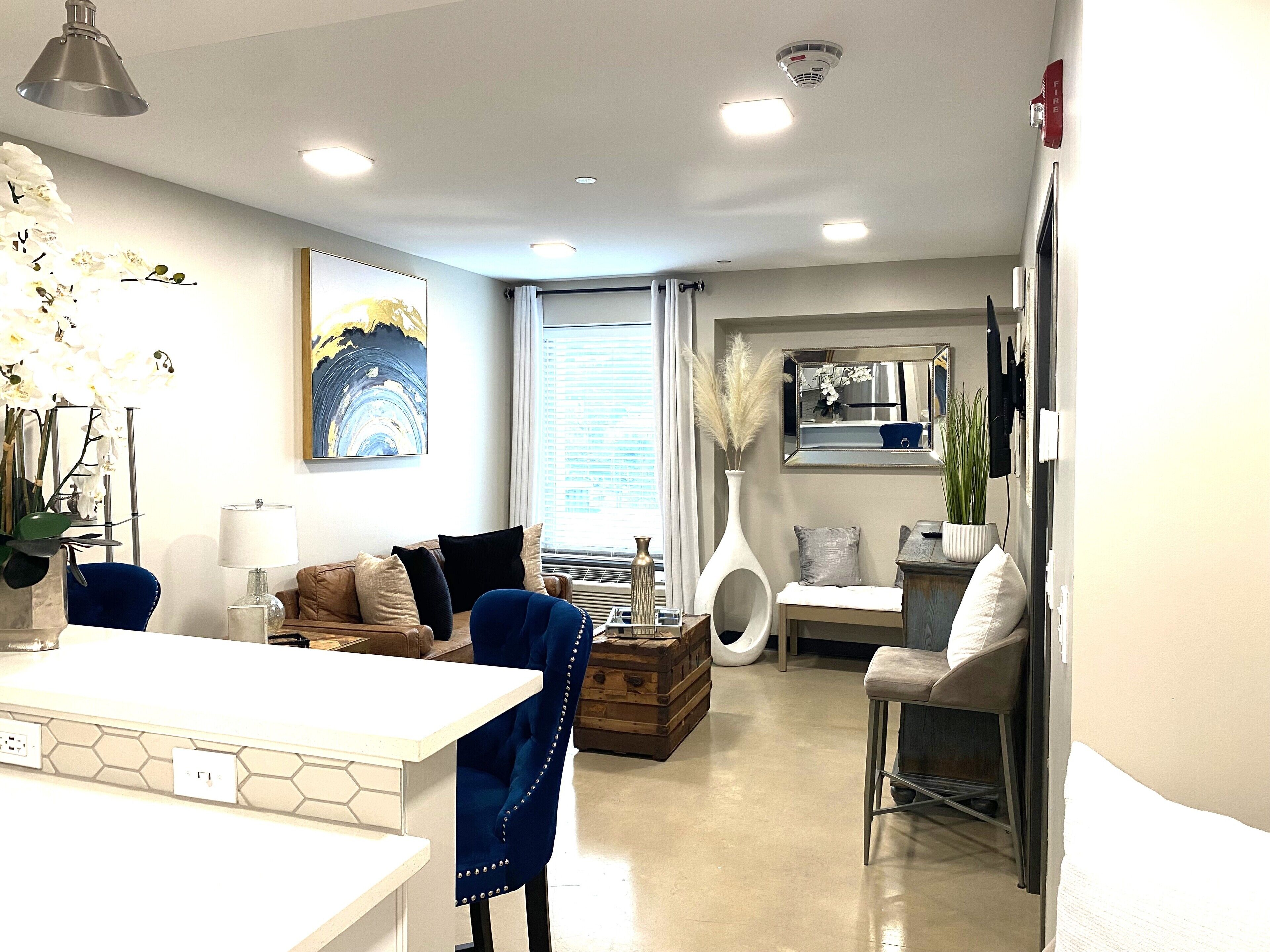 A modern living room with a sofa, coffee table, and a dining area with a white table and chairs.
