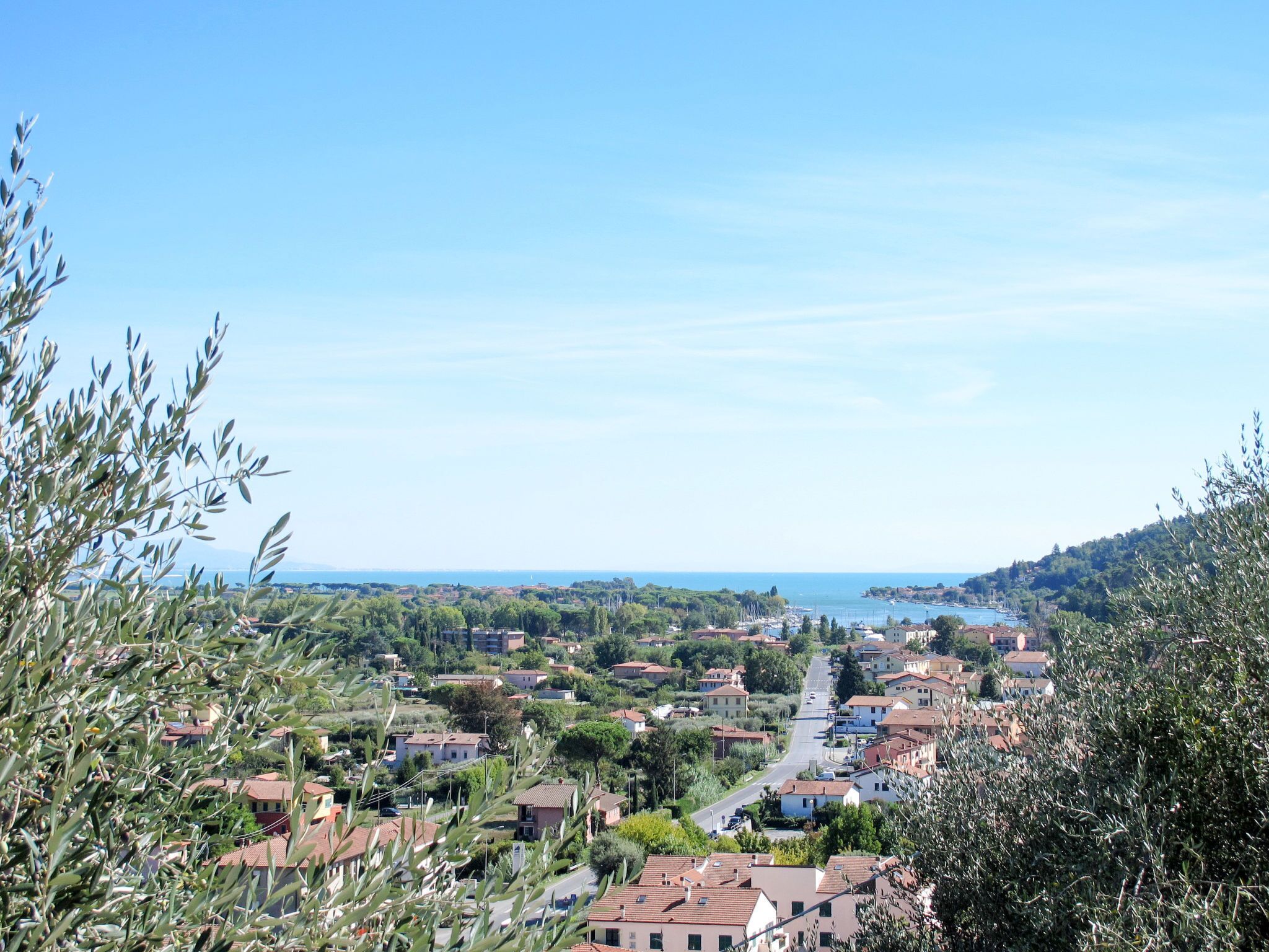 Eine Küstenstadt mit terrassenförmig angeordneten Häusern, blauem Himmel und Blick aufs Meer.