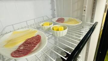 Un refrigerador con estantes que contienen alimentos y recipientes.