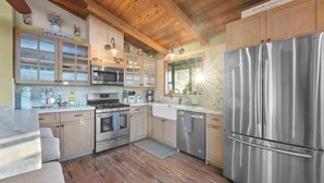 A modern kitchen with wooden cabinets, stainless steel appliances, and a large refrigerator. - Eagles Nest•Walk to Village (Big Bear Lake)