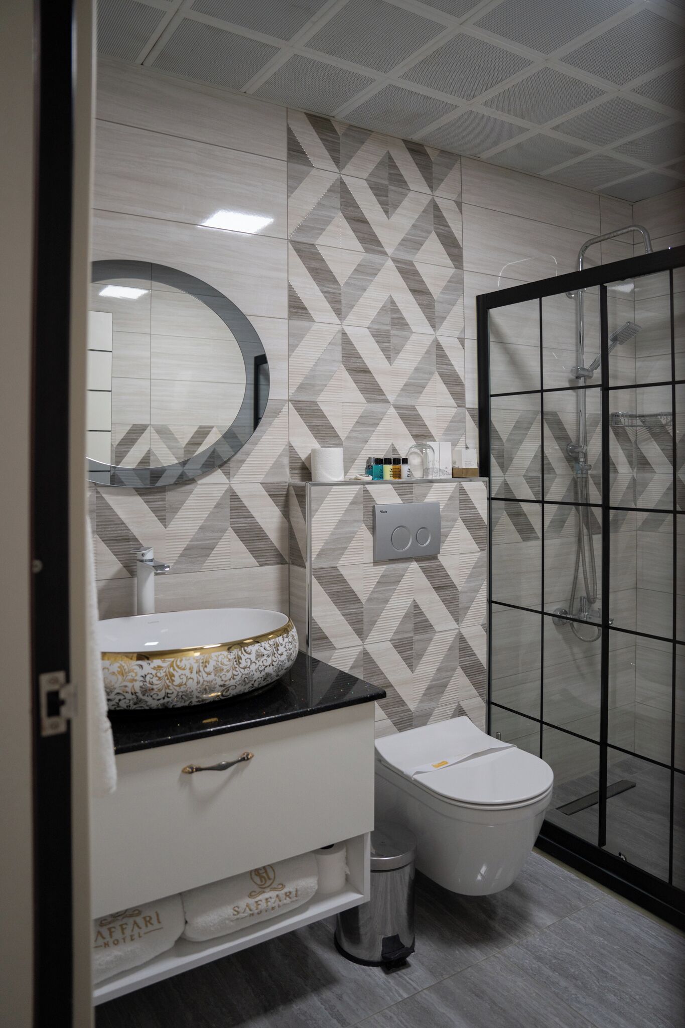 A modern bathroom with a vanity, sink, mirror, toilet, and shower area.