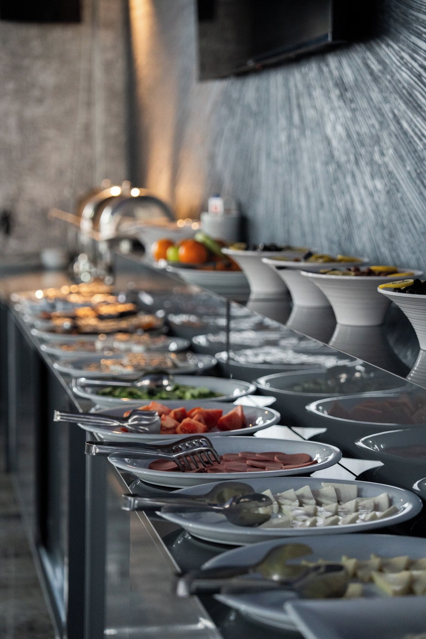 Una barra de buffet con diversos alimentos y utensilios.