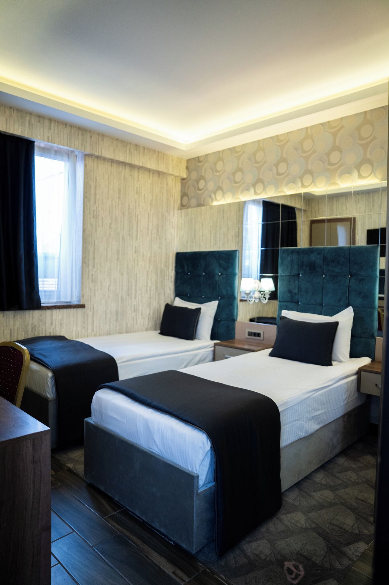 Une chambre d’hôtel avec deux lits, un bureau et une chaise.