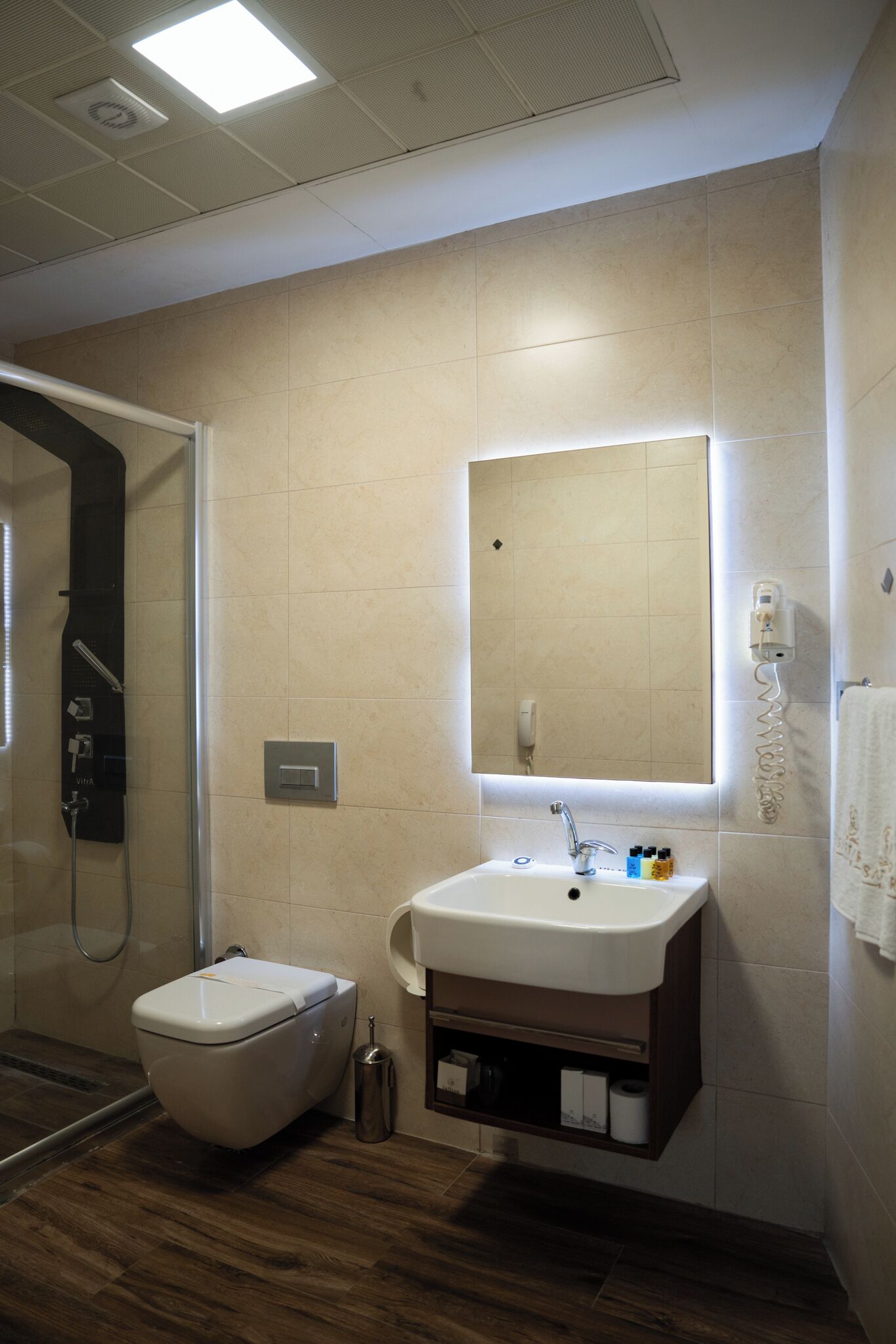 Un baño moderno con inodoro, lavamanos y ducha.