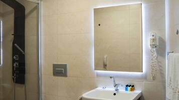 Un baño moderno con inodoro, lavamanos y ducha.