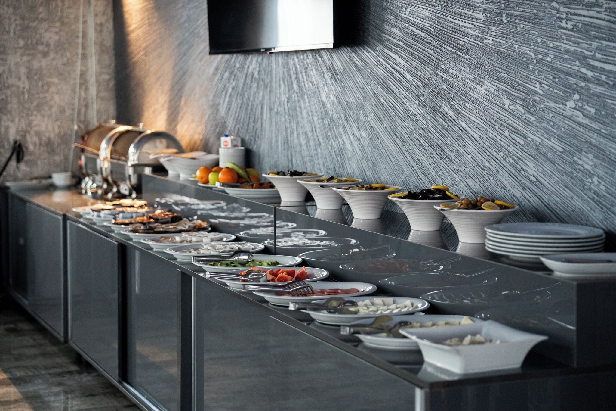 A buffet setup with various food items and dishes arranged on a long table.