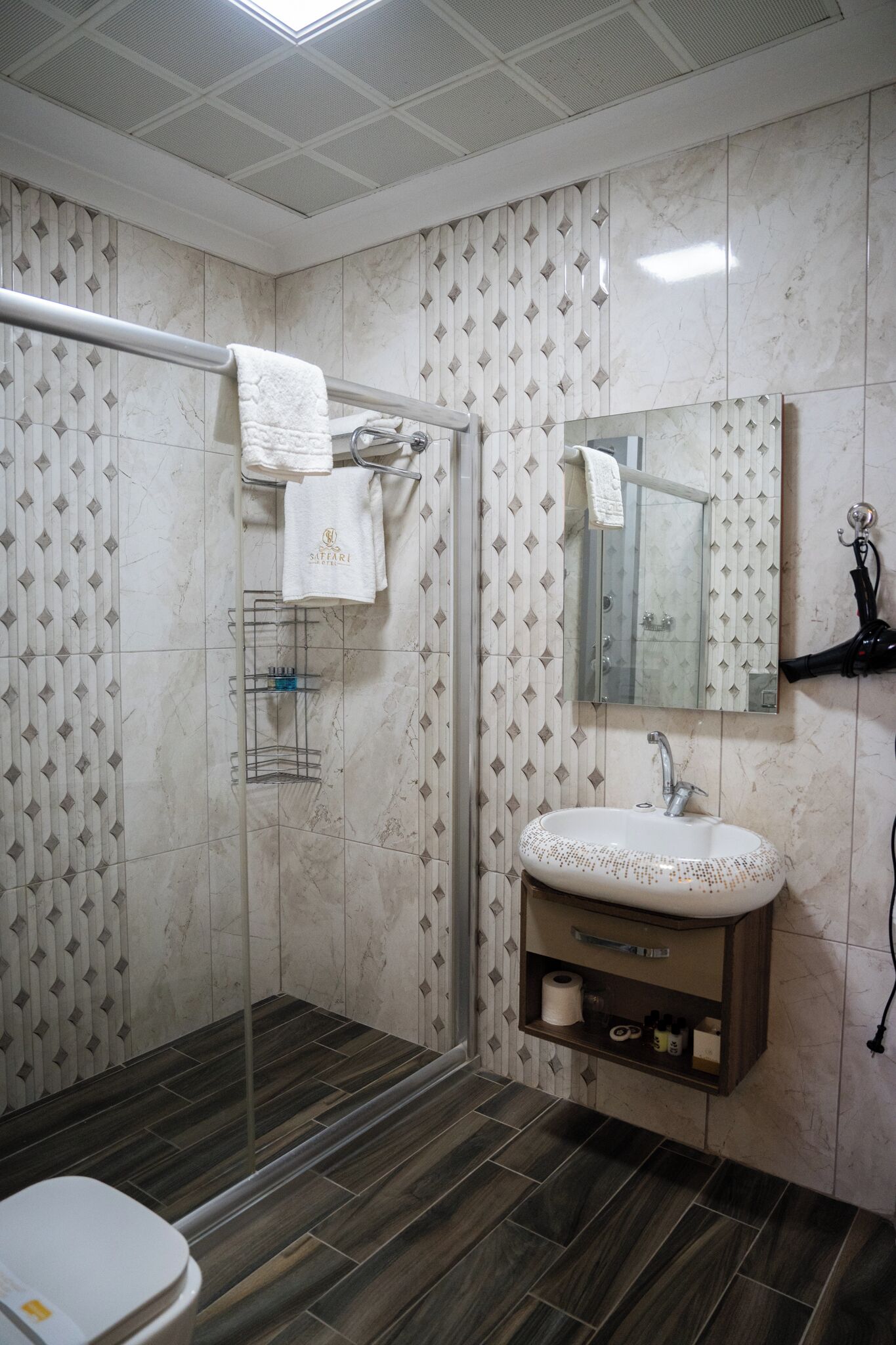 A bathroom with a shower, a sink, and a mirror.