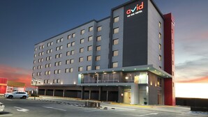 A modern hotel with a prominent 'Avia Hotel' sign, multiple floors, and a covered entrance area. - avid hotel Guadalajara Aeropuerto Norte by IHG (Tlaquepaque)
