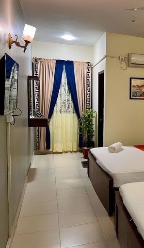 Relax in a serene space with a comfortable bed, bedside table, and potted plant.