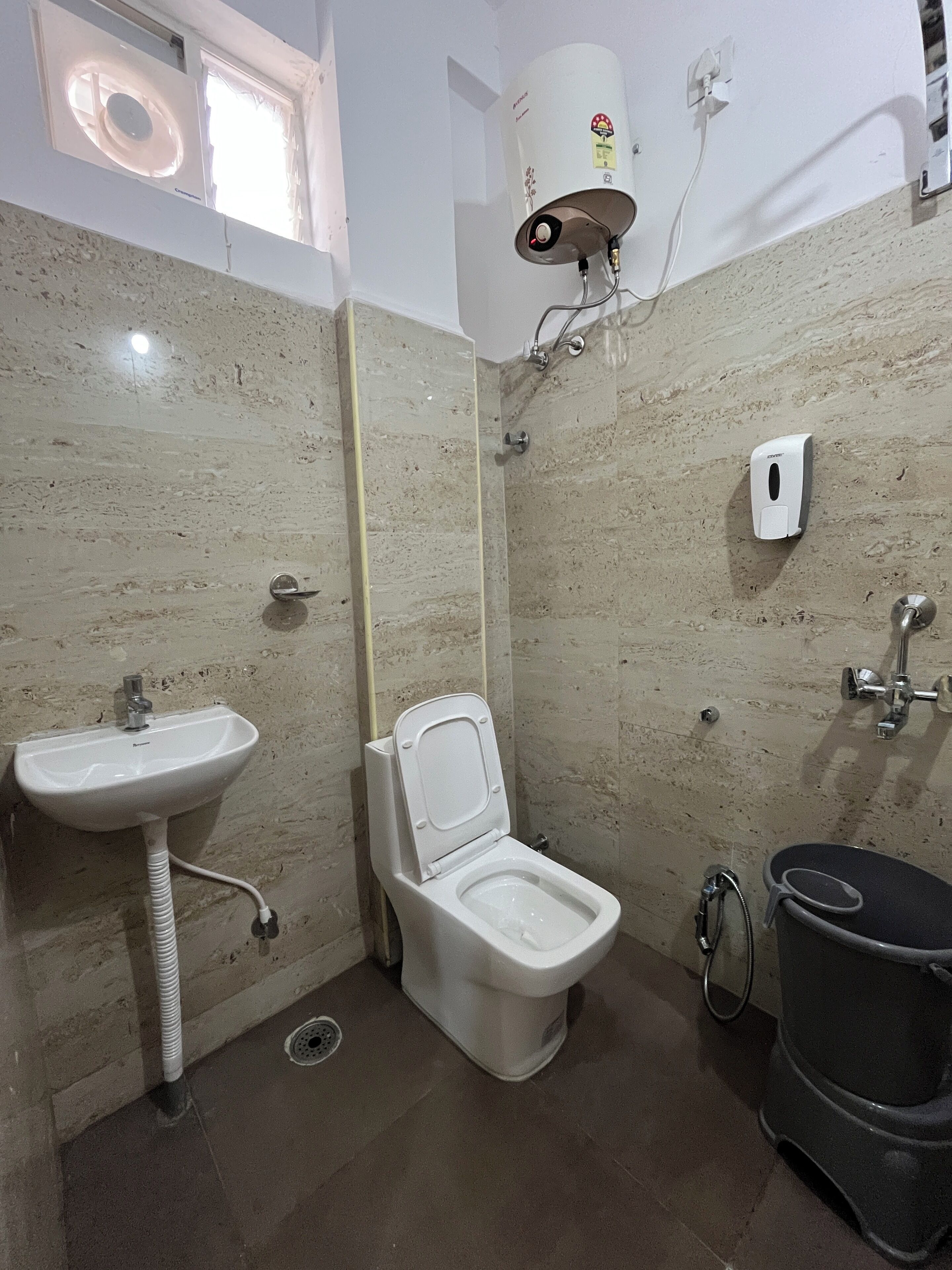 Une salle de bain avec des toilettes, un lavabo et une douche.