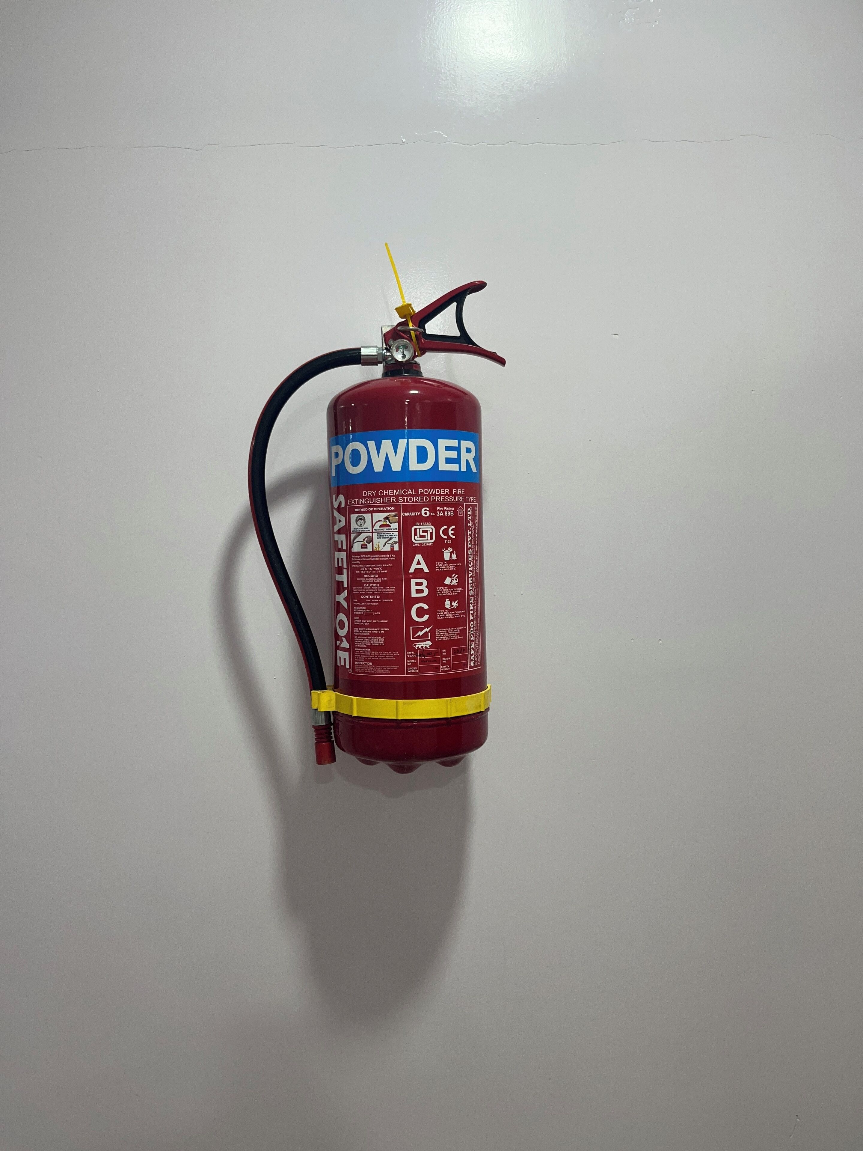 Brandblusser bevestigd aan een witte muur.