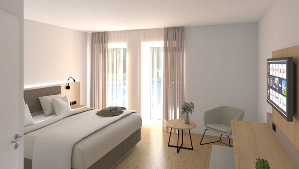 Een moderne hotelkamer met een bed, nachtkastje, lamp, televisie en een zithoekje met een stoel en tafel.