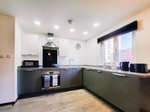 Enjoy cooking in this well-equipped kitchen with a microwave, oven, and range hood.