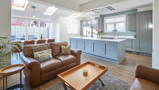 A modern kitchen with grey cabinets, a central island, and pendant lighting. - Host Stay Peasholm Place (Scarborough)