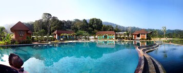 Una piscina al aire libre, sillones reclinables de piscina
