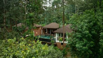 A secluded resort with multiple bungalow-style buildings, a swimming pool, and lush greenery surrounding the property.