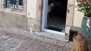 Entrada de un edificio con puerta, una ventana con reja de metal y una planta en maceta.