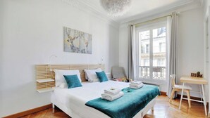 Quarto moderno com uma cama grande, uma escrivaninha e uma cadeira.