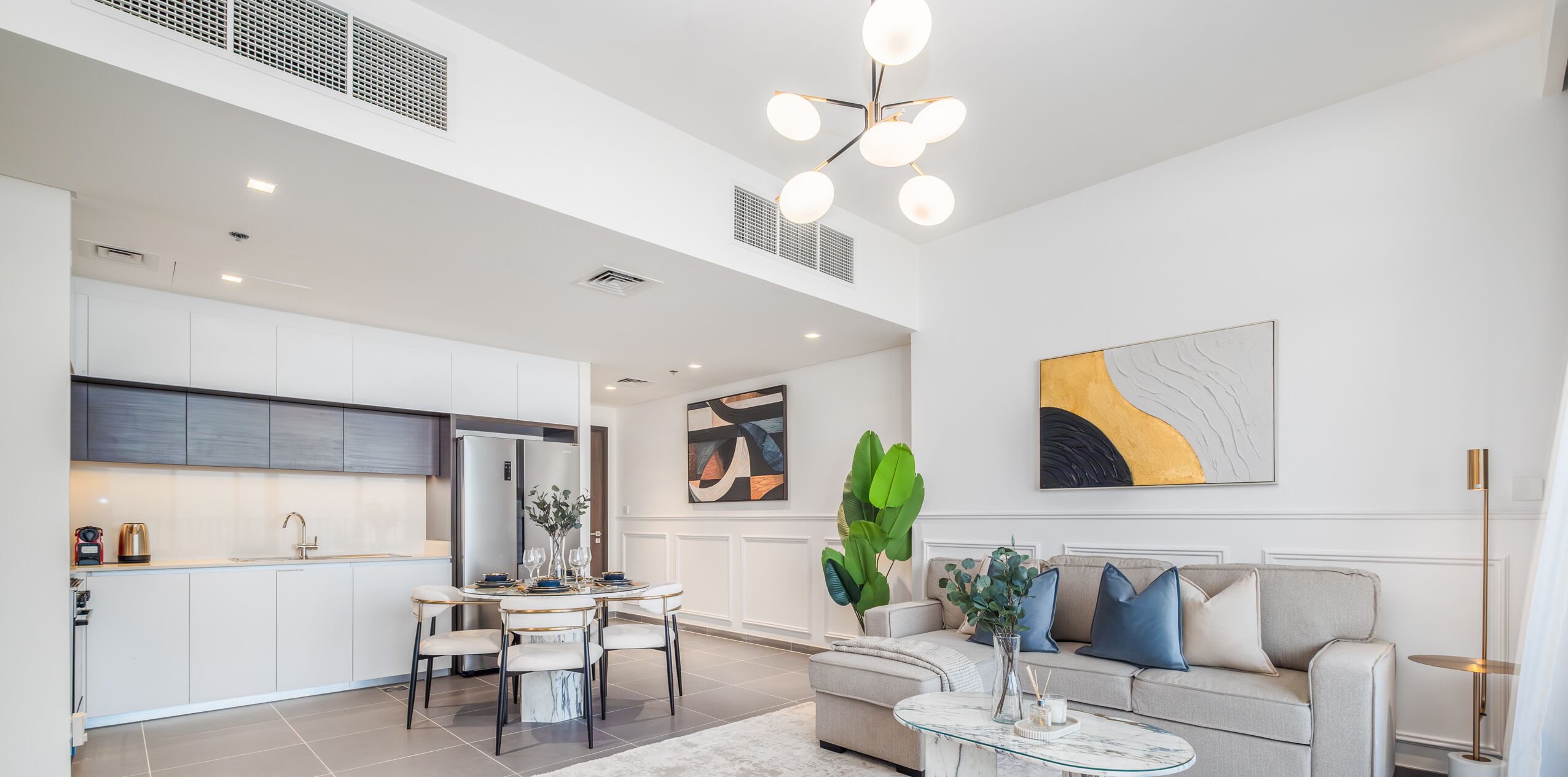 A modern living space with a dining area, kitchen, and seating area.