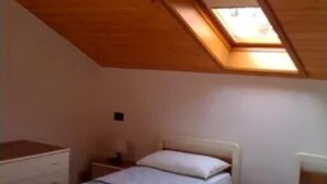A small bedroom with two single beds, a wooden ceiling, and a skylight. - Apartment for 8 people in a quiet area in Pellizzano - Via G. Tomaselli, 6 (Pellizzano)