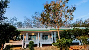 A two-story house with a green roof, white exterior walls, and a porch with white railings. - PhuLanta Resort (Ko Lanta)