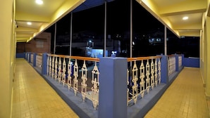 Un pasillo con barandilla azul y vista al cielo nocturno.