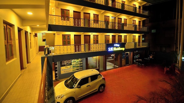 Un hotel de dos pisos, con un automóvil estacionado adelante y un letrero que dice 'E Stay & R Residency'.