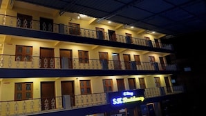 Un hotel de varios pisos con balcones, cada uno con barandilla y ventana.