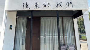 A two-story building with a sign in Japanese characters. - Here after us (Dahu)