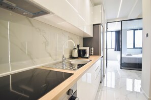 Deluxe appartement | Privékeuken | Een koelkast met diepvriezer, een microgolfoven, een oven, een kookplaat