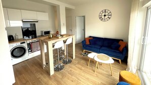 A modern living space with a kitchen, dining area, and seating area. - Apartment "Le Clémenceau", downtown, fully equipped (Saint-Brieuc)