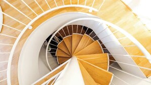 A spiral staircase with wooden steps and white railings.