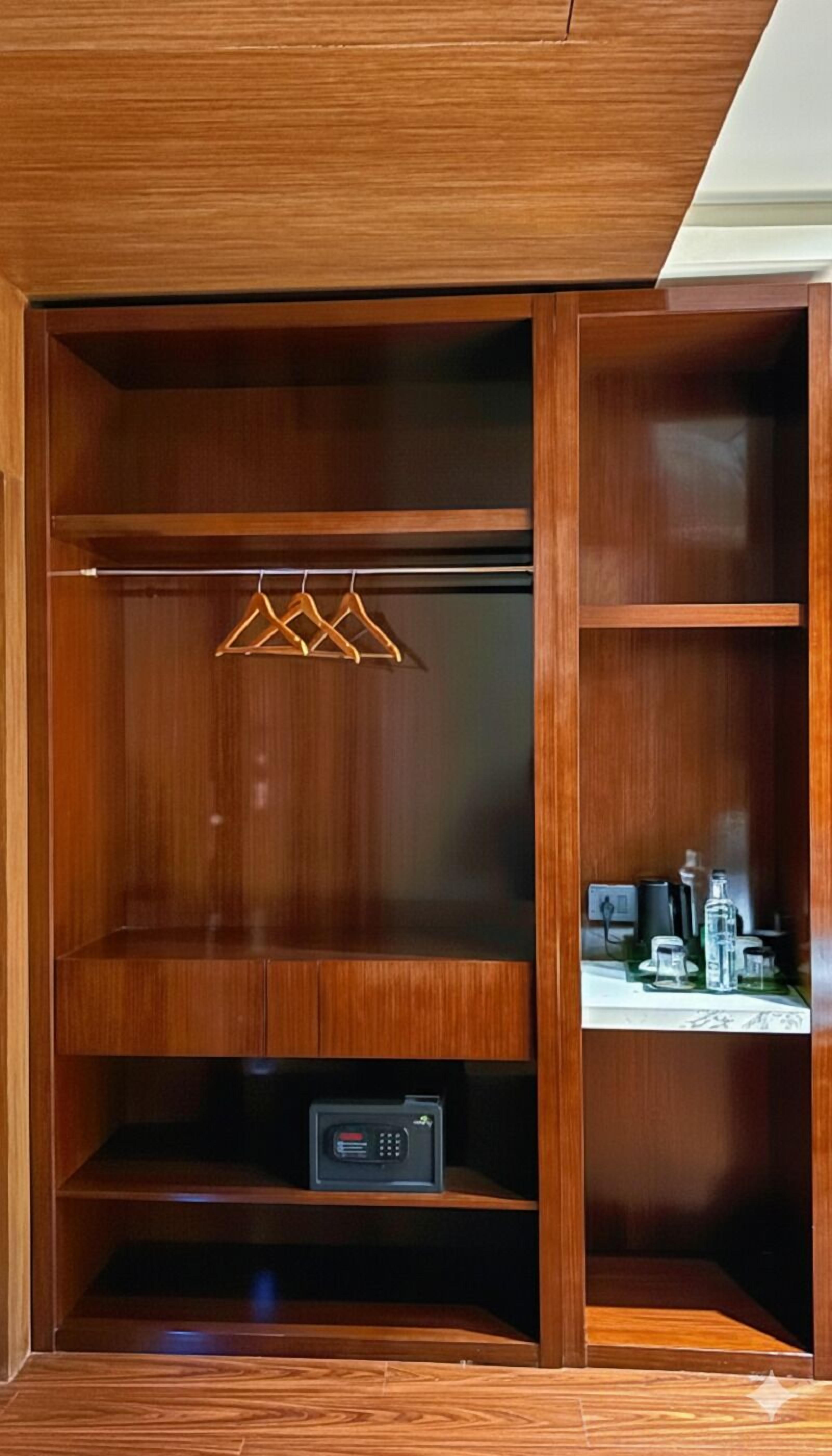 Un armario de madera con estantes y una barra para colgar ropa.