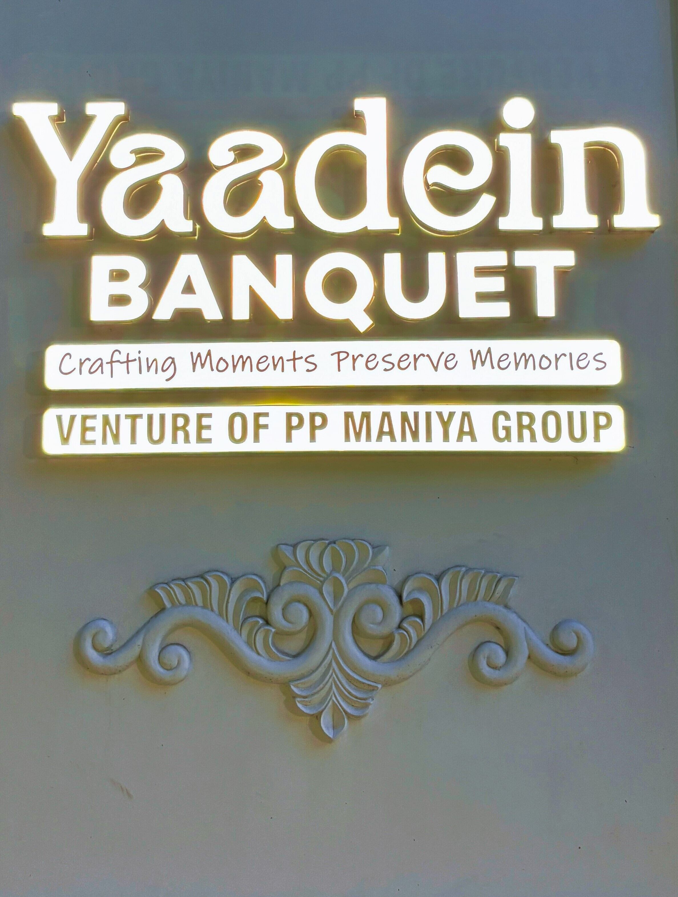 A sign with the text 'Yaadein Banquet' and 'Crafting Moments Preserve Memories' along with 'Venture of PP Maniya Group'.